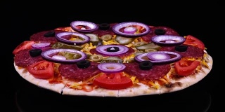 色彩缤纷的披萨，配有泡菜、意大利腊肠、橄榄、奶酪、新鲜番茄和洋葱圈