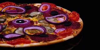 美味的自制披萨，配上泡菜、意大利腊肠、番茄、橄榄、奶酪和洋葱圈