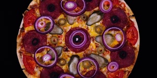 俯视图自制披萨与泡菜和洋葱刚刚从烤箱旋转在黑色背景