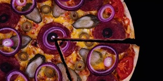 俯视图自制披萨与泡菜和洋葱刚从烤箱，切下一片旋转在黑色背景