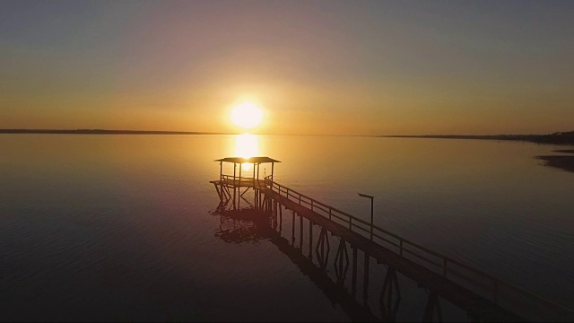 无人机镜头视图:在金色的夕阳下飞过一个小码头