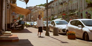 一个女人走在美丽的街道上的正面视图