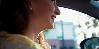 近距离的年轻女子开车和微笑