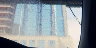 洗车的第一步，方便的泡沫压力喷射，在美丽的商业中心前面的玻璃幕墙
