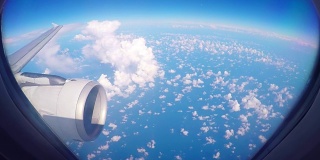 透过喷气式飞机窗户看到的云朵。飞机在高空飞行。
