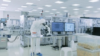 在无菌高精密制造实验室里，科学家们穿着防护服使用计算机和显微镜，做制药、生物技术和半导体研究。视频素材模板下载