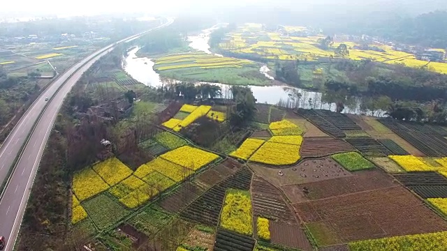 鸟瞰中国四川乡村景观与油菜籽田和高速公路交通，4k