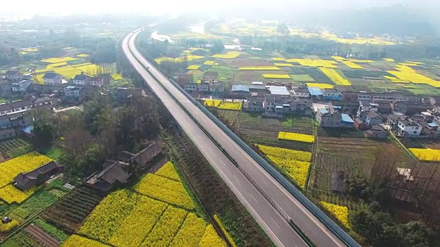 鸟瞰中国四川乡村景观与油菜籽田和高速公路交通，4k