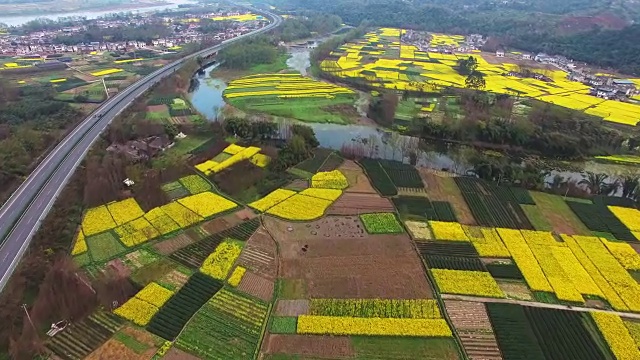 鸟瞰中国四川乡村景观与油菜籽田和高速公路交通，4k