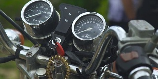 摩托车仪表盘上的速度计、里程表和点火钥匙。关闭摩托车控制面板