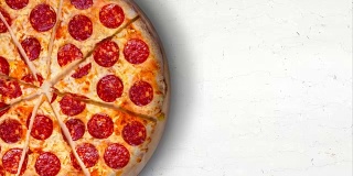 白色大理石餐桌上放着意大利辣香肠披萨。