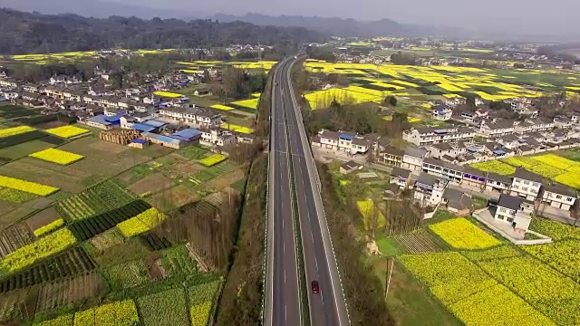 鸟瞰图的中国乡村景观在春天油菜种子盛开和村庄在高速公路