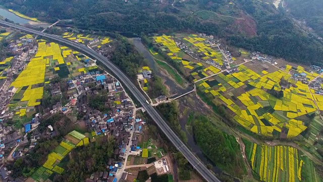 鸟瞰图的中国乡村景观在春天油菜种子盛开和村庄在高速公路