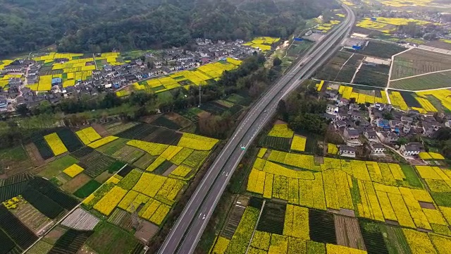 鸟瞰图的中国乡村景观在春天油菜种子盛开和村庄在高速公路