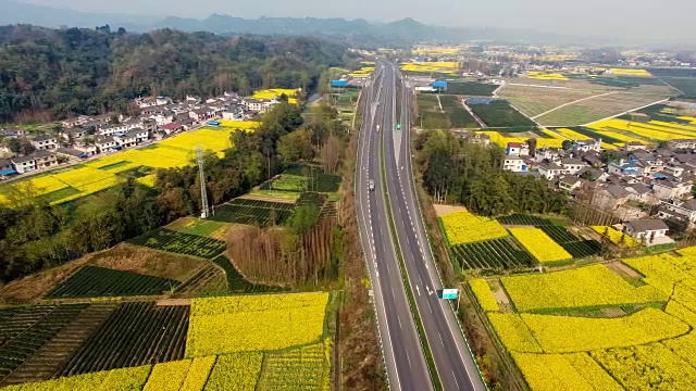 鸟瞰图的中国乡村景观在春天油菜种子盛开和村庄在高速公路