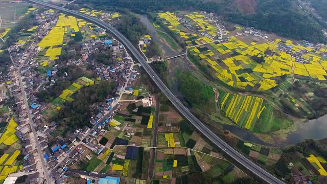 鸟瞰图的中国乡村景观在春天油菜种子盛开和村庄在高速公路