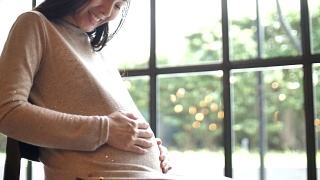 孕妇轻轻抚摸着肚子，怀孕/分娩视频素材模板下载
