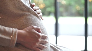 孕妇轻轻抚摸着肚子，怀孕/分娩视频素材模板下载