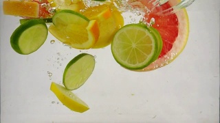 几片柠檬、柠檬、橙子、葡萄柚等柑橘类水果落入水中，溅起水花和气泡，这是慢镜头特写视频素材模板下载