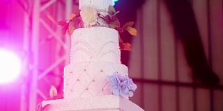 美丽的婚礼蛋糕装饰鲜花和蜡烛在婚宴上。