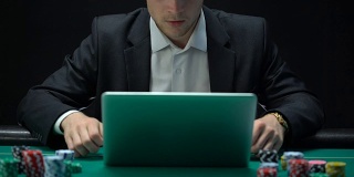 赌徒在笔记本电脑上玩，显示成功的姿态，赢赌注，财富