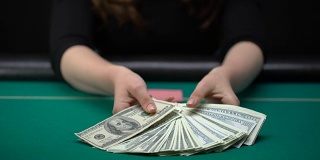 看牌的女人把钱放在赌桌上，浪费钱
