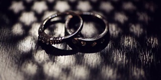 牛皮纸盒子上的两个结婚戒指。黑暗的场景