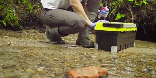 采集水样本的女性生态学家
