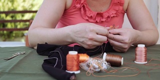 女裁缝坐在沙发上用针编织花边，慢动作