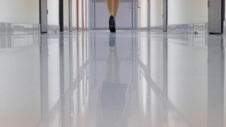 一个穿着黑色高跟鞋的女人走在办公楼的走廊上视频素材模板下载