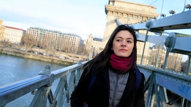 快乐的旅游女孩走在城市访问欧洲城镇的桥上。120帧慢动作的女人走路