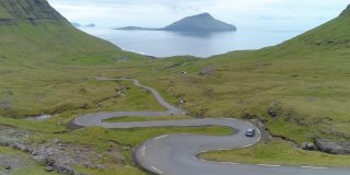 航拍:汽车沿着蜿蜒的乡间小路驶向法罗群岛海岸
