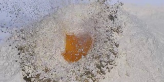 鸡蛋在白色背景下落入面粉，慢镜头