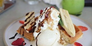 慢镜头将蜂蜜倒在薄饼冰淇淋甜点上
