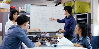 男工程师与团队一起参与项目。团队工程师一起启动机器人项目。有技术或创新观念的人。4 k决议。