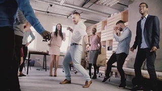 在团队建设公司庆典派对上，快乐的欧洲商人与同事们围成一圈跳舞视频素材模板下载