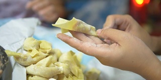 亚洲妇女手工制作馄饨和饺子馅。