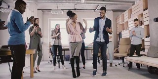 快乐的非裔美国员工在办公室聚会上跳有趣的民族舞蹈，庆祝商业成就的慢动作