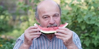 老人在炎热的夏天吃西瓜。