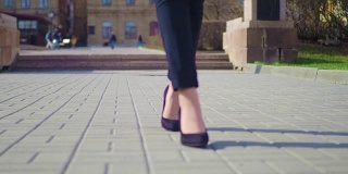 女人的脚在市中心行走的特写镜头。穿着高跟鞋的女商人