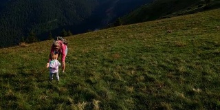 母亲和蹒跚学步的孩子在夏天爬山