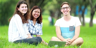 一群微笑的学生在花园公园里，慢镜头