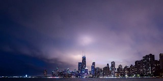 随着时间的推移，戏剧性的积云在芝加哥和密歇根湖的水面上移动，城市的灯光在建筑物上和直升机经过。