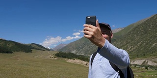 快乐的旅行者拍摄视频或照片全景山谷电话