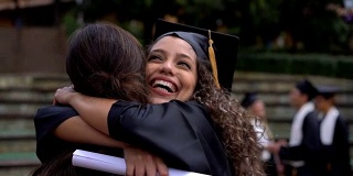 在大学获得学位后，快乐骄傲的学生跑去拥抱她的妈妈