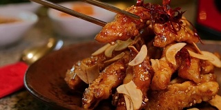 用筷子慢慢举起韩式脆鸡。