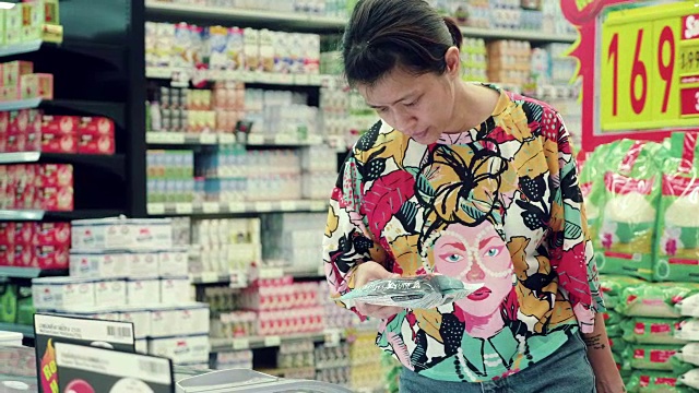 亚洲妇女在超市购买冷冻食品。