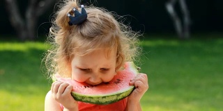 小女孩吃了一个西瓜。宝宝在夏天吃东西。特写肖像