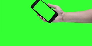 手持智能手机在绿色屏幕背景