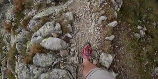 一名男子徒步行走在悬崖边缘，在塔特拉山脉国家公园的山谷中观看波兰旅游旅游的狂热